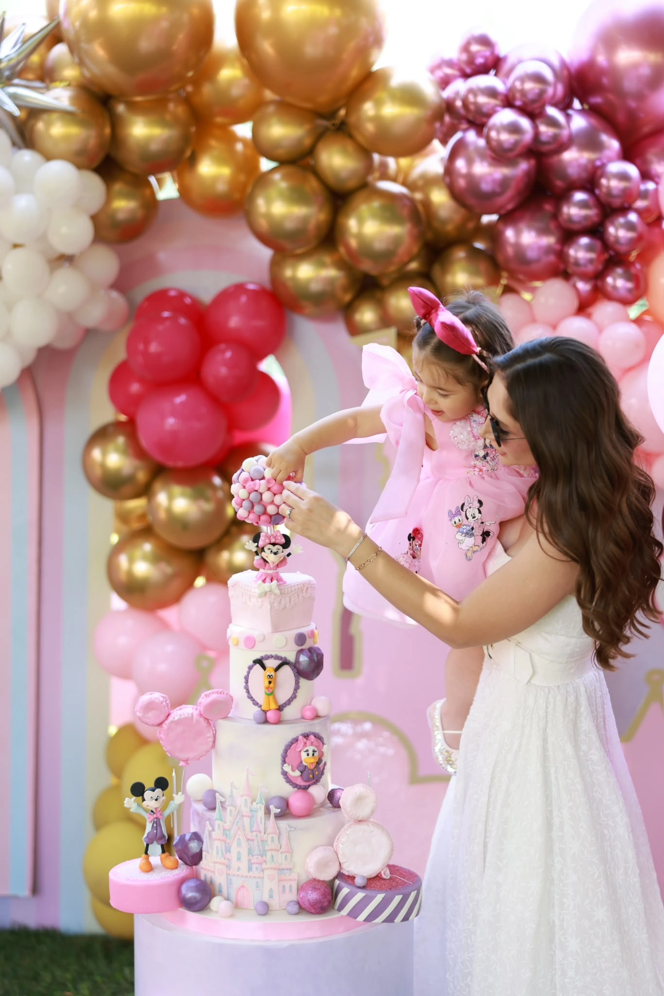 Altın ve pembe balonlar önünde doğum günü pastası