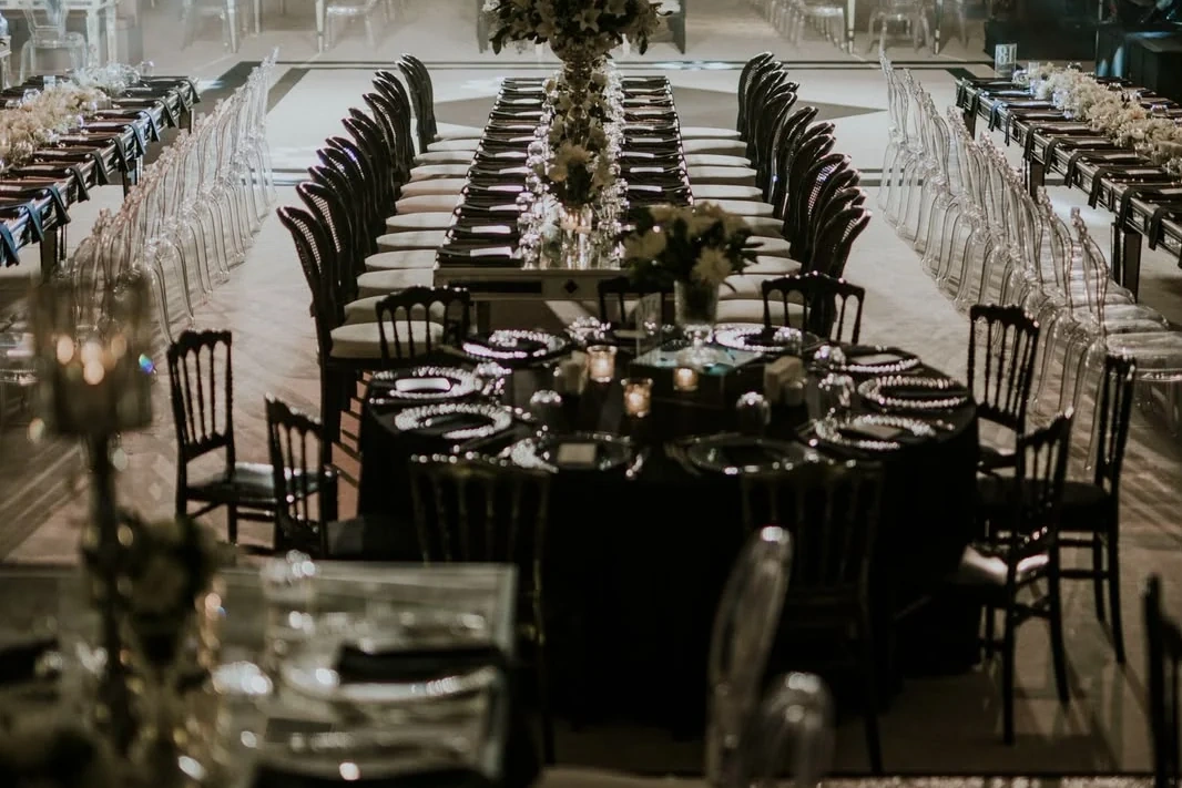 Koyu sofralar ve şeffaf sandalyelerle hazırlanan salon düğünü