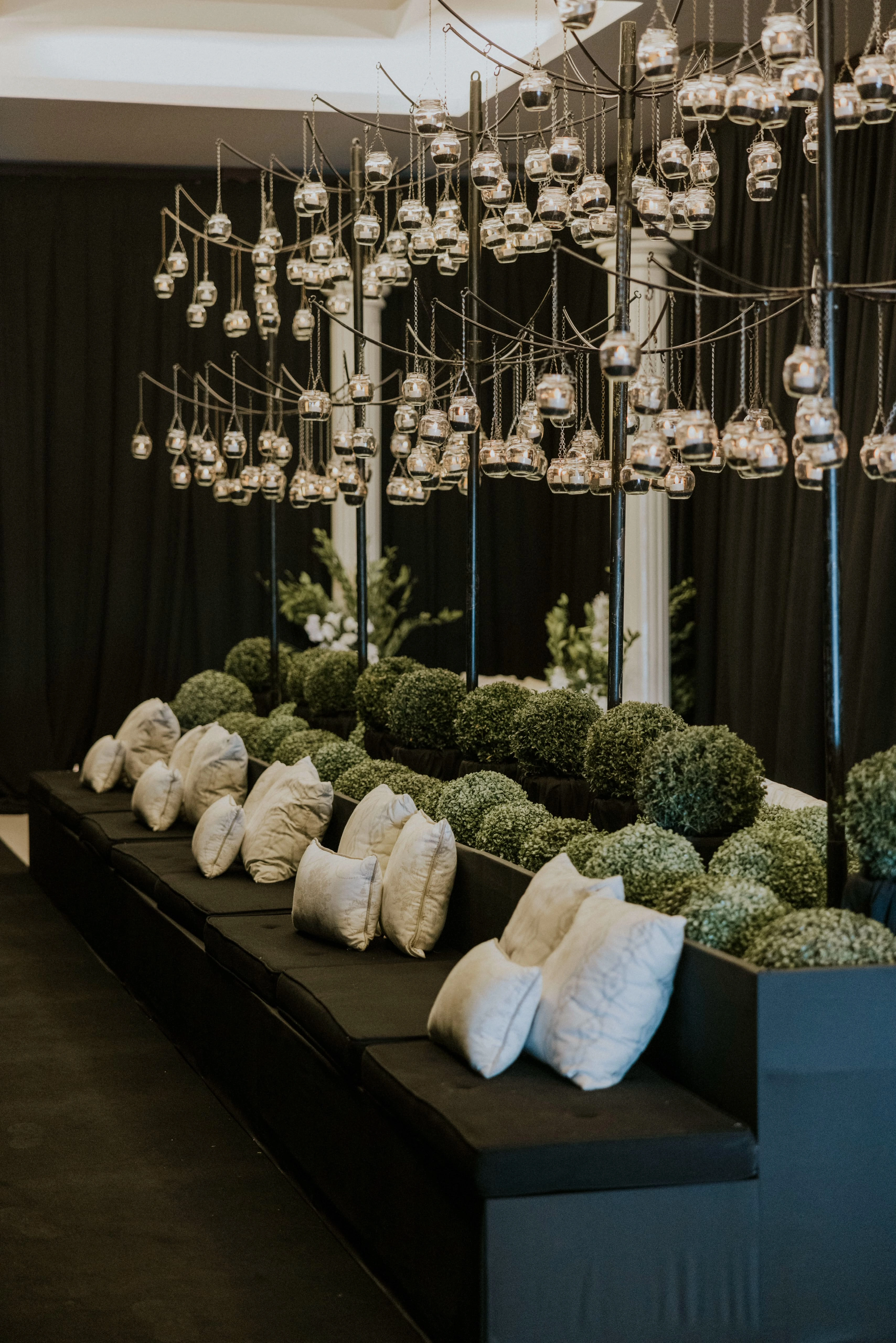 Yeşil heykelsi yüzeyler ve asılı mumluklarla hazırlanan lounge