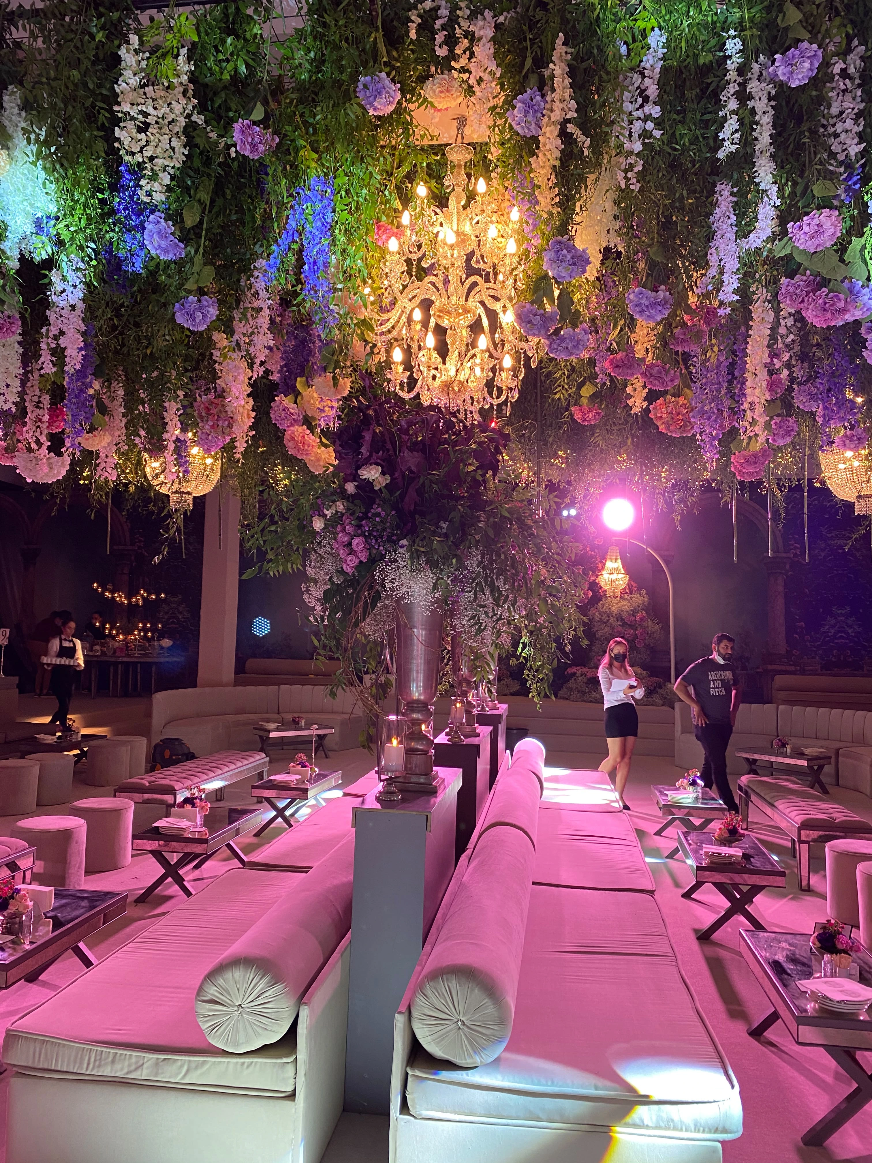 Mor ışıkta kristal avize ve pembe lounge alanı