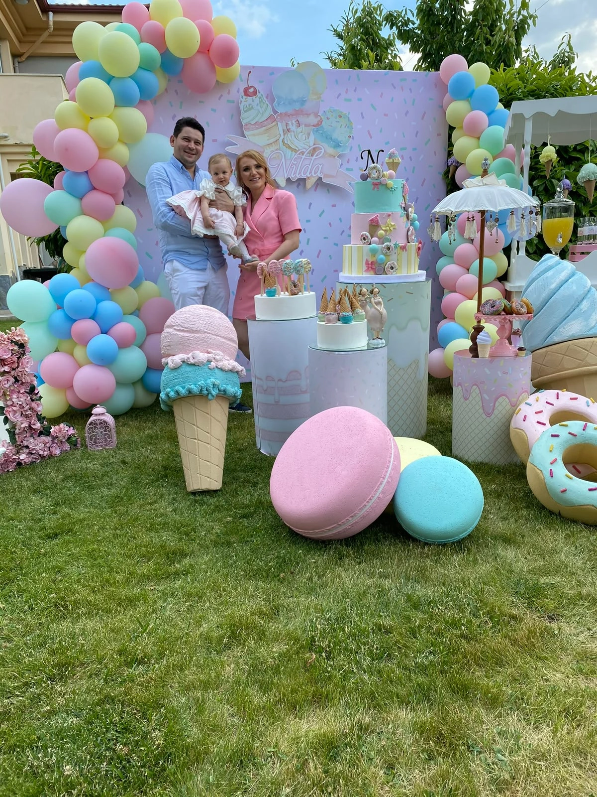 Pastel balonlar ve büyük şekerleme objeleriyle hazırlanan bahçe sahnesi