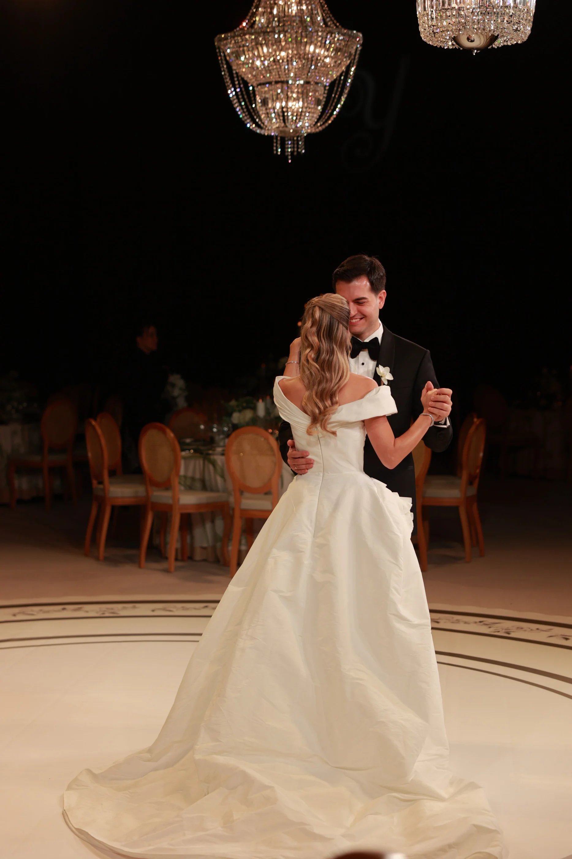 Kristal avizelerin altında dans eden gelin ve damat